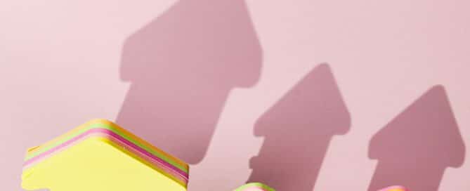 Coins with rising arrow symbols, representing dividend reinvestment and compound investment growth.